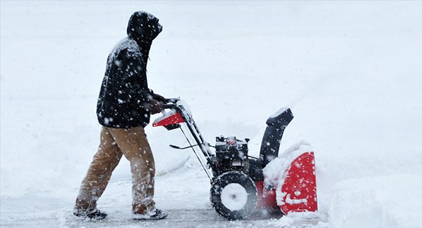 Picture of a person snow blowing.