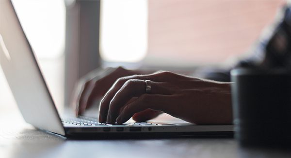 Picture of hands typing on a computer.