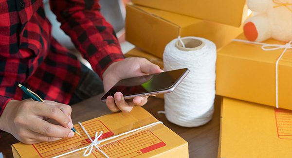 Picture of a person labeling a box to put out for shipping.