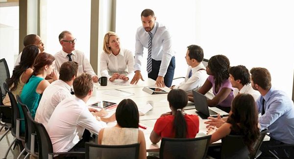 Picture of a group of people having a meeting around a table.