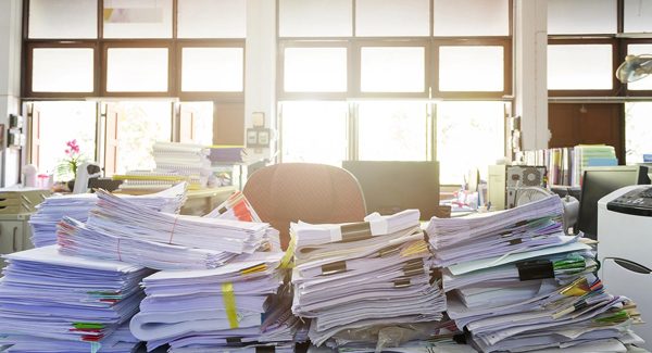 Picture of stacks of paper on a desk.