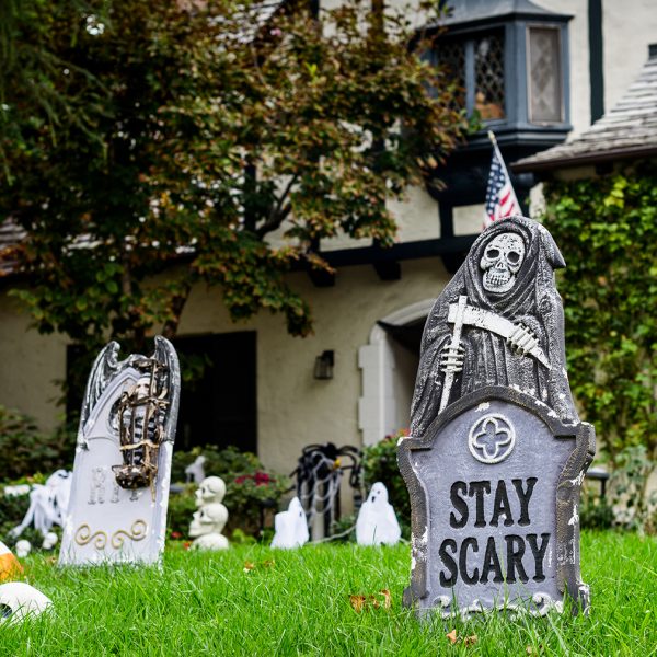 Halloween decorations on front lawn of house.