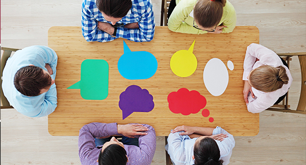 Picture of people sitting at a table with word balloons