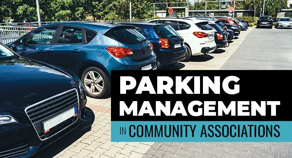 A row of parked cars in a lot with a sign reading "Parking Management in Community Associations.