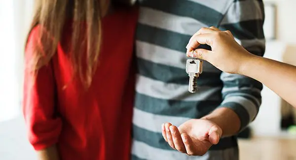 house keys being handed to a couple.
