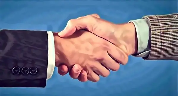 Two people wearing business attire are shaking hands against a blue background.
