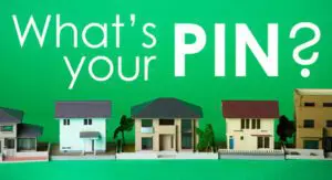 Five model houses lined up in front of a green background with the text "What's your PIN?" displayed above them.