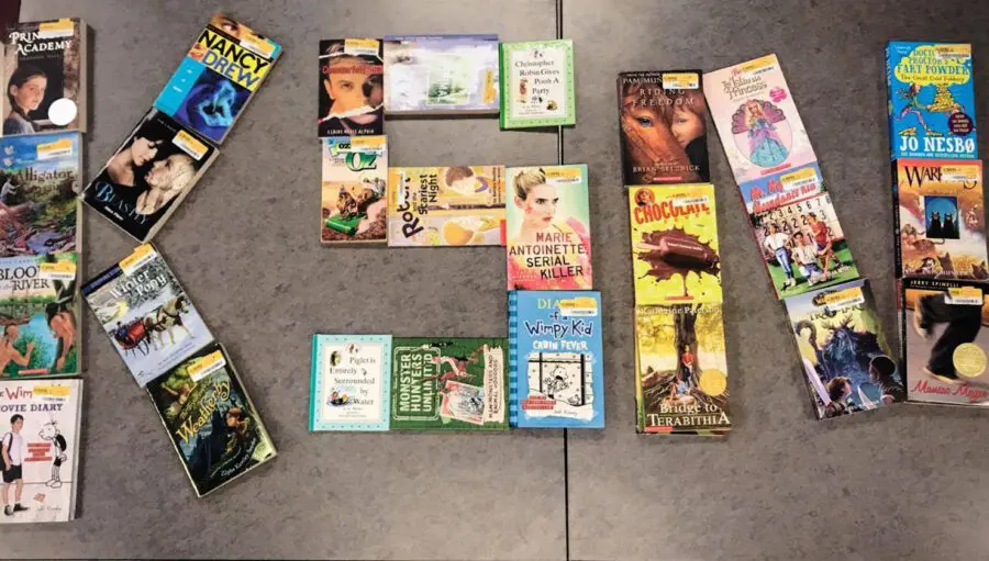 Books are arranged on a flat surface to form the word "READ," with a variety of children’s and young adult titles visible.