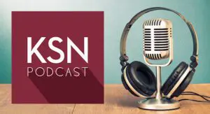 A vintage microphone with headphones rests on a wooden table next to a maroon square graphic displaying the text "KSN PODCAST.
