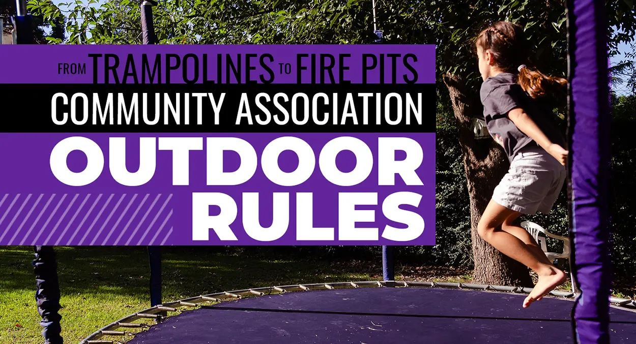 A girl jumps on a trampoline outside near trees, alongside a sign about community association outdoor rules for trampolines and fire pits.