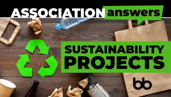 Top view of recyclables like paper, plastic, and glass on a wooden table with green recycle arrows and bold text reading "Association Answers: Sustainability Projects.