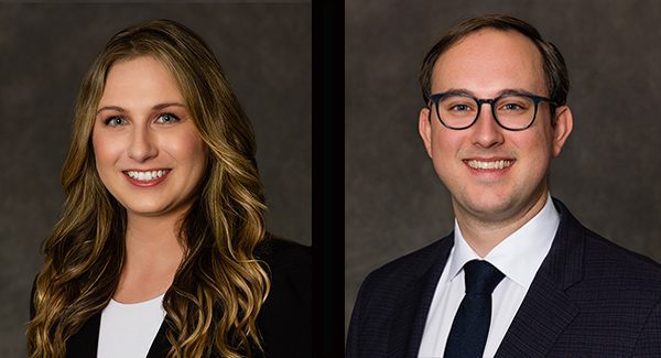 Professional portraits of a woman with long wavy hair and a man with glasses, both wearing business attire and smiling against a dark background.