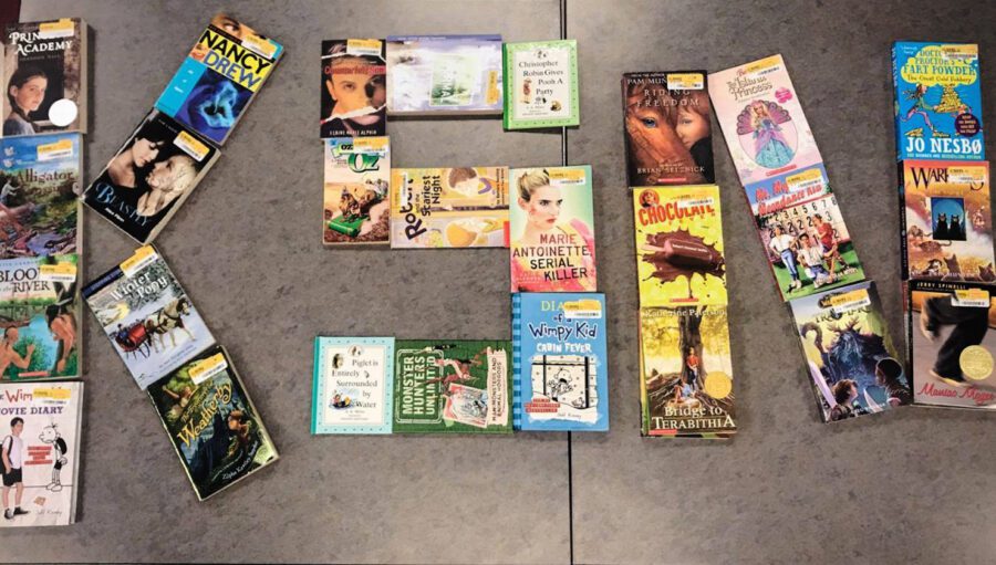 Books are arranged on a flat surface to form the word "READ," with a variety of children’s and young adult titles visible.