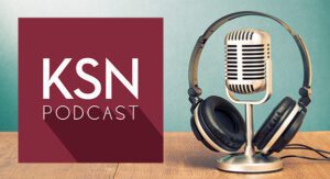 A vintage microphone with headphones rests on a wooden table next to a maroon square graphic displaying the text "KSN PODCAST.