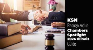 Two people in business attire shake hands across a desk with legal books and documents; text announces KSN's recognition in the Chambers Spotlight 2026 Illinois Guide.